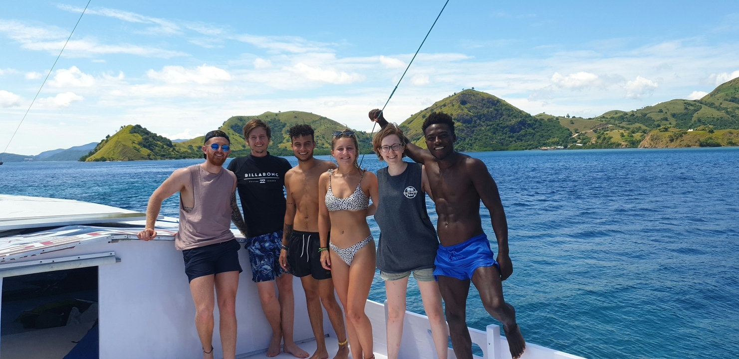 Group of people aboard a boat enjoying the island scenery.