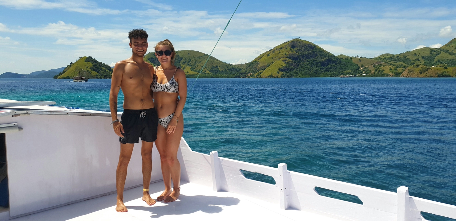 Couple on a boat with scenic island views.