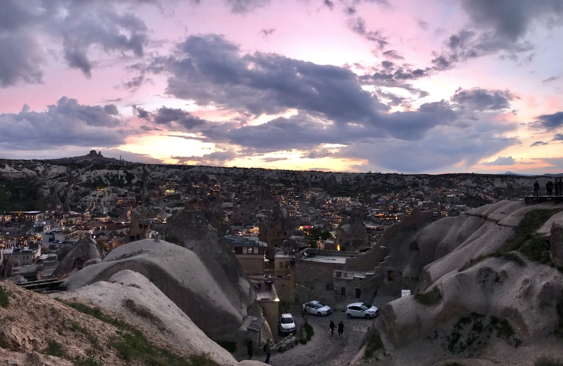 Panoramic view of a city built into rock formations at sunset.
