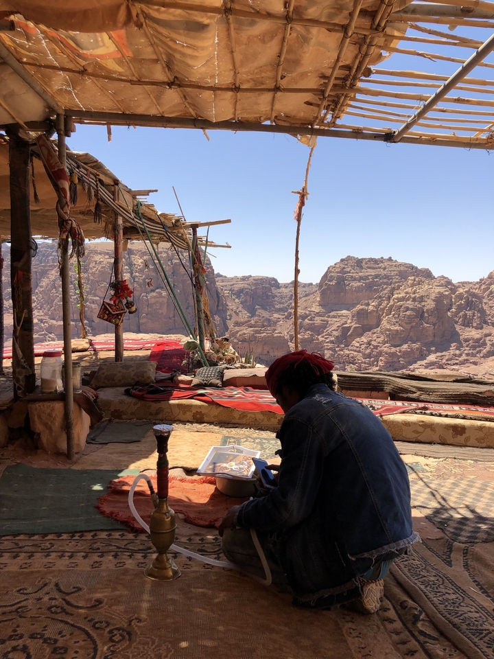 Person sitting in a tent with a stunning view of mountains
