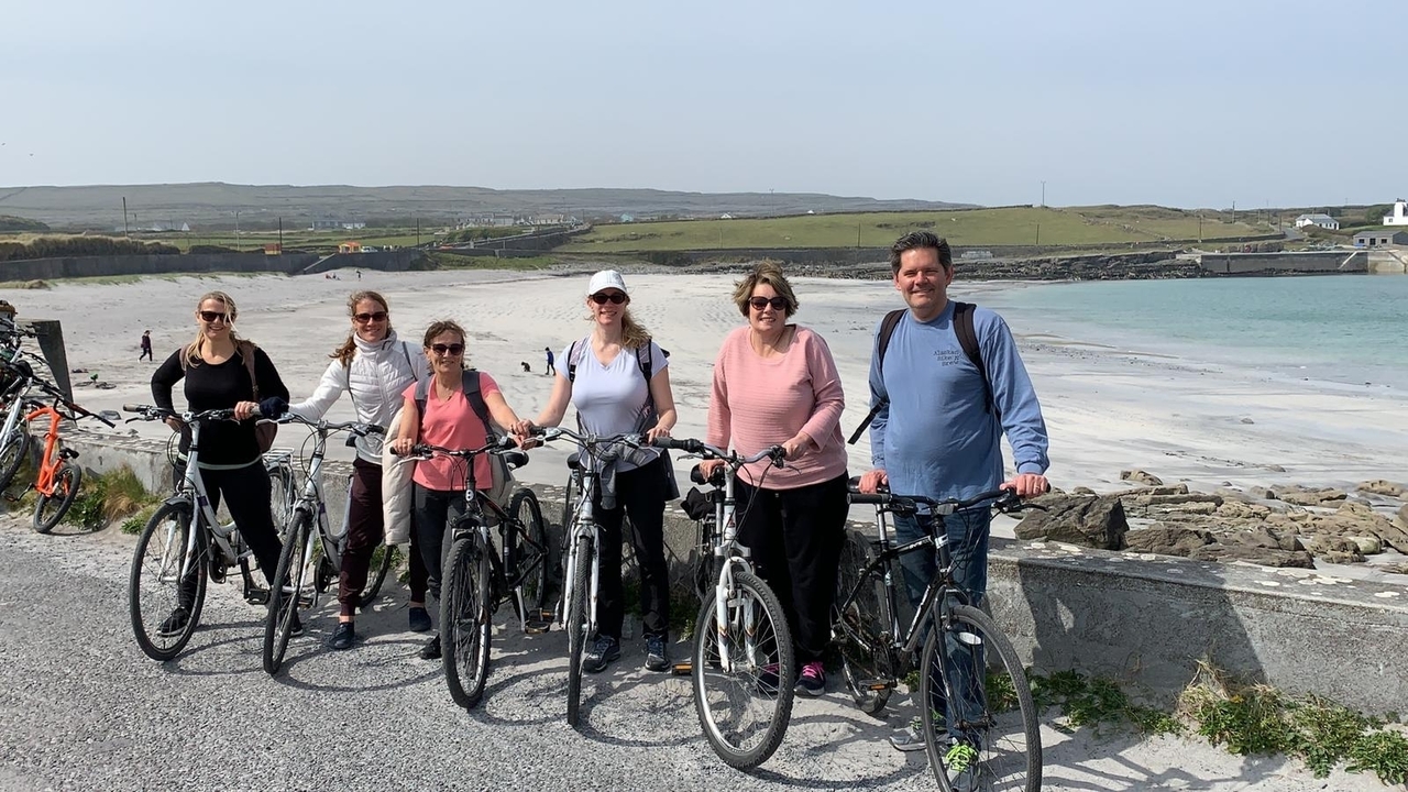 Groupe avec vélos sur un sentier côtier avec une plage
