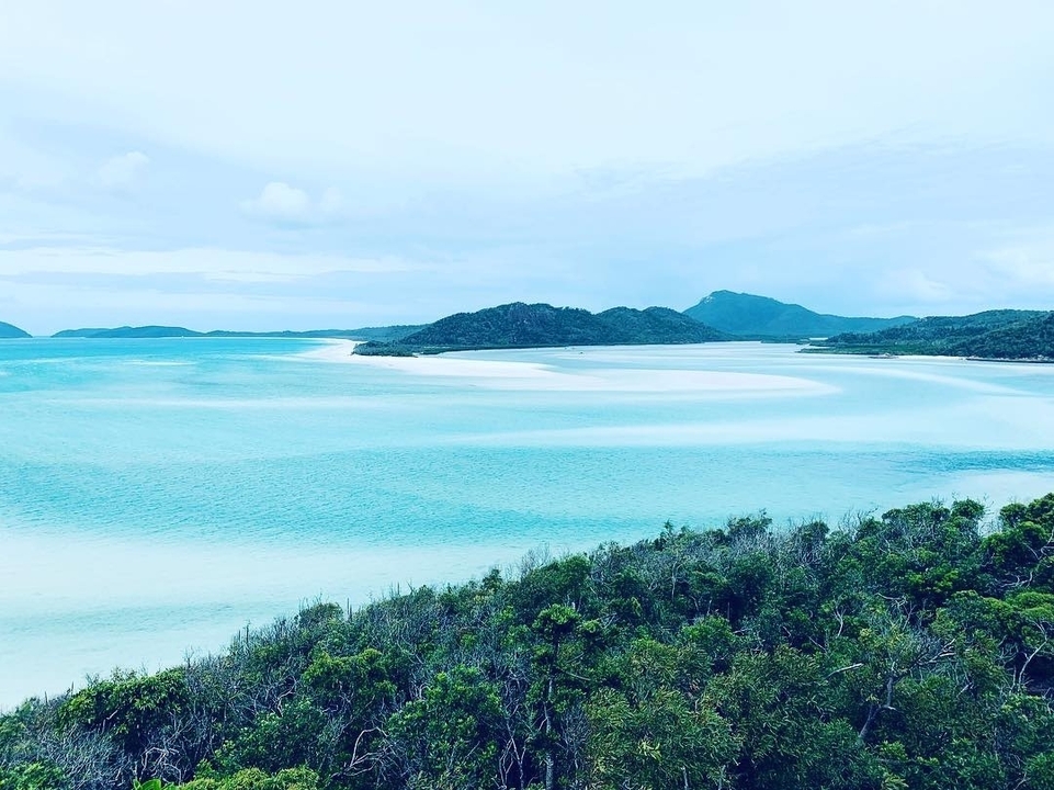 Aerial view of a tropical beach with turquoise waters and islands.
