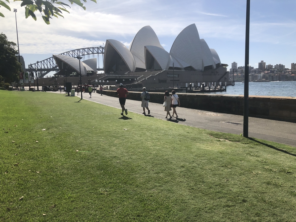 Tourists walking near the iconic Sydney Opera House.