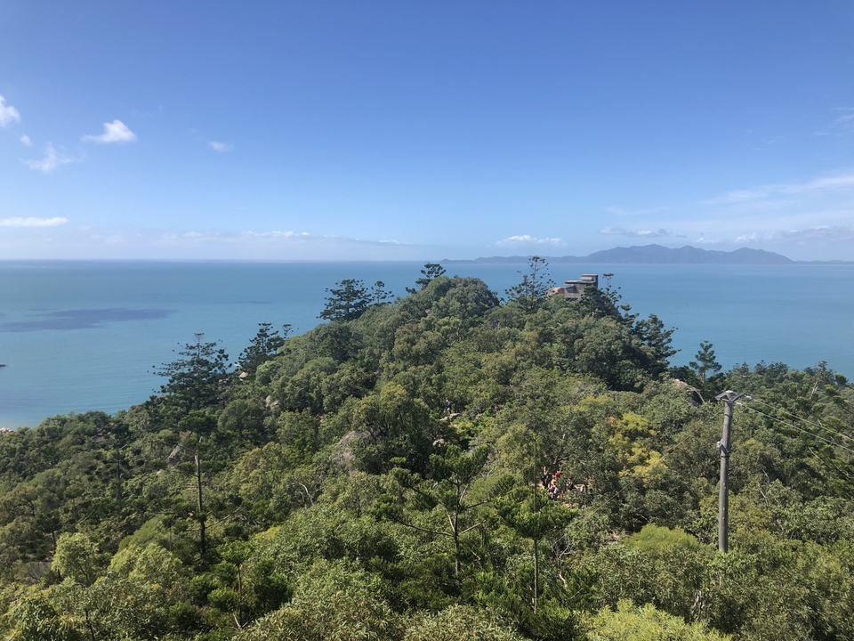 Scenic view from a hill overlooking a tropical coastline.