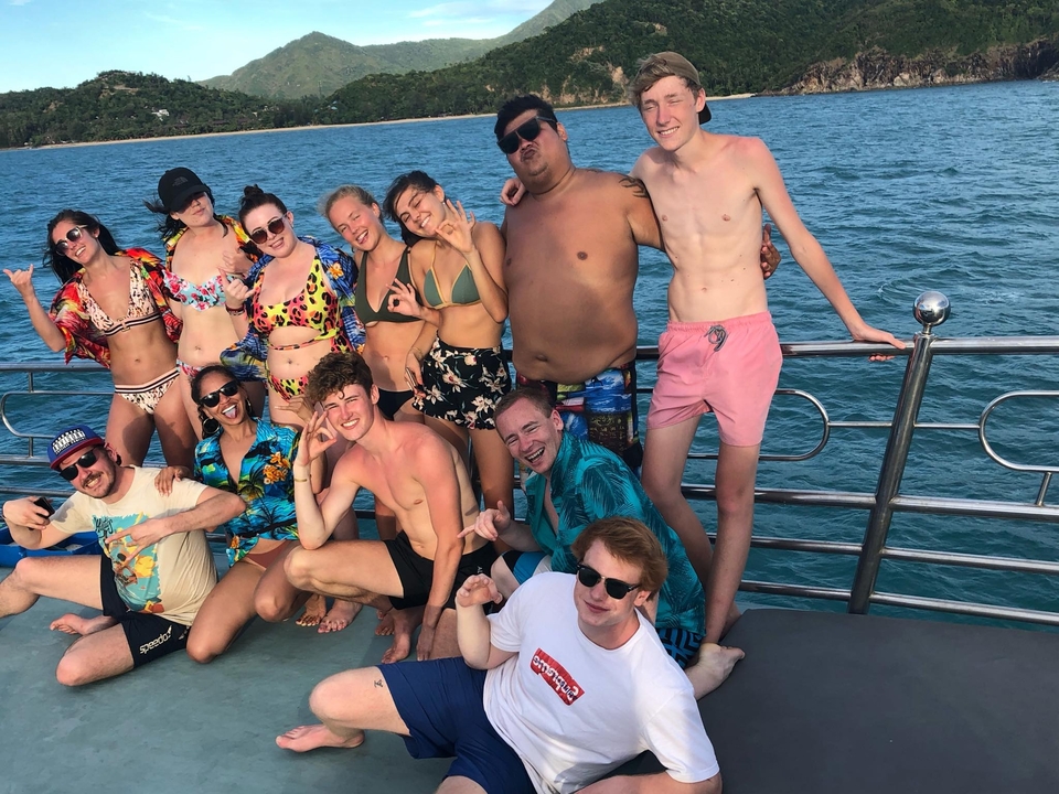 Group on a boat with the sea in the background.