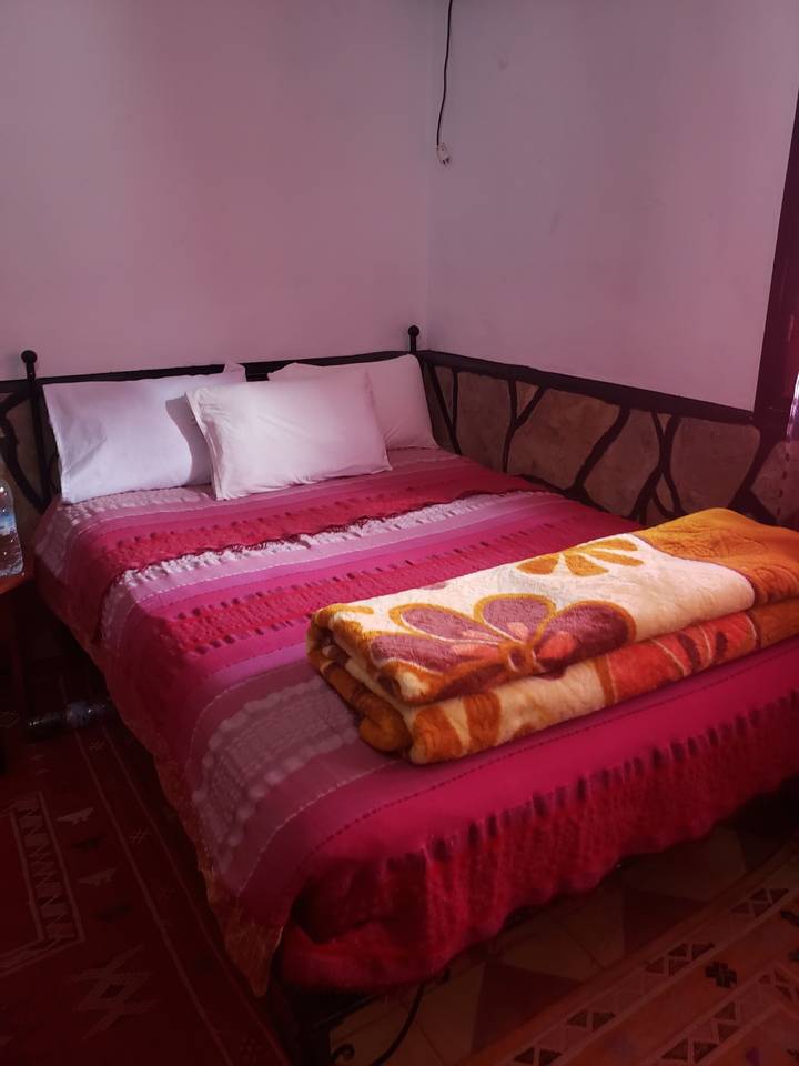 Lit coloré avec des couvertures dans une chambre.