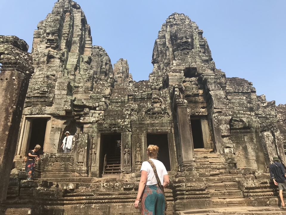 Person exploring ancient temple ruins potentially Bayon Temple.
