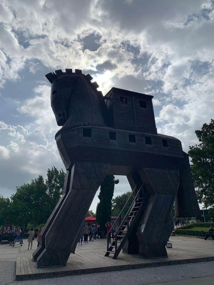 Sculpture de cheval de Troie en bois dans un parc.
