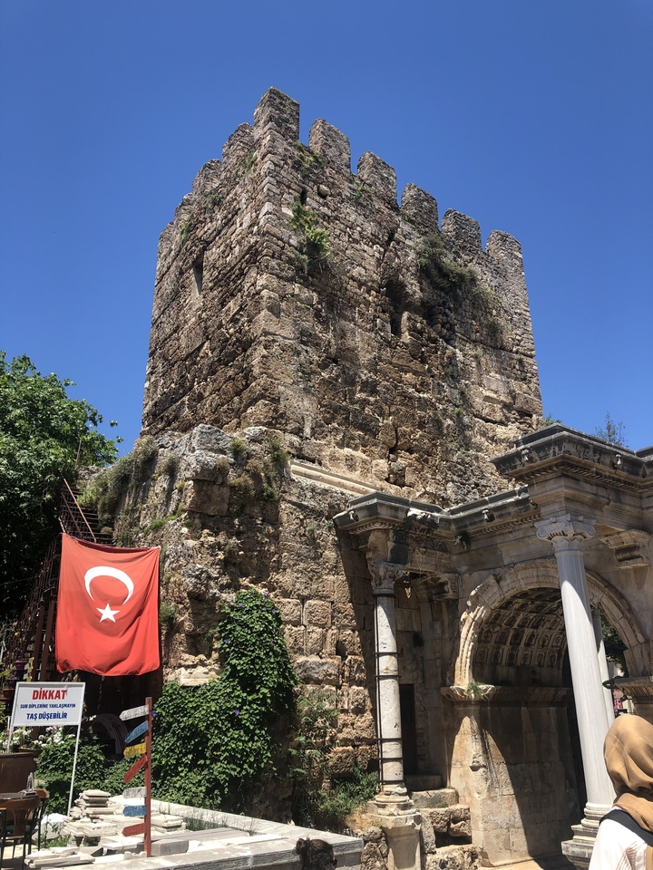 Tour de pierre ancienne avec un drapeau turc drapé devant.