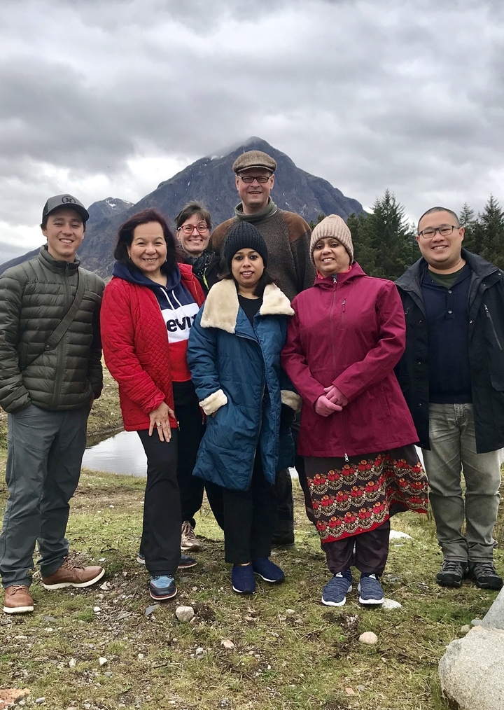 Group of people standing outdoors in warm clothing.