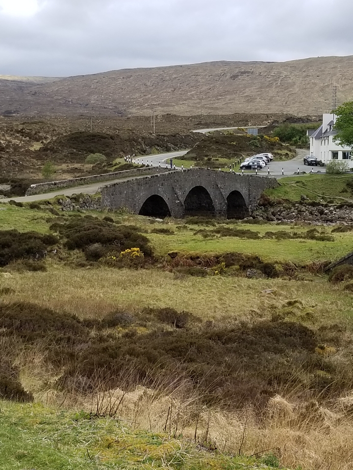 Un ancien pont de pierre enjambant un petit ruisseau.