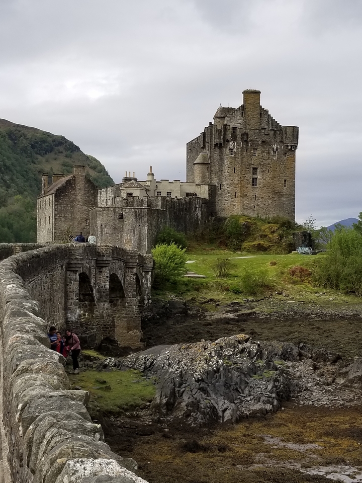 Château historique avec un pont de pierre au premier plan.