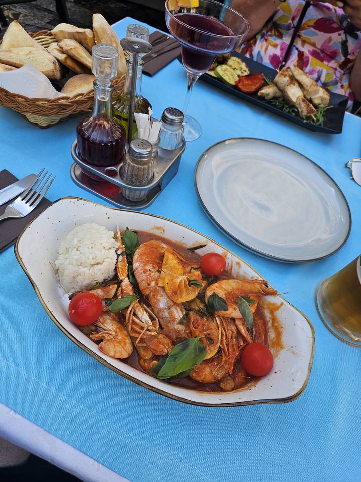 Seafood dish with shrimp, tomatoes, and rice served on a plate.