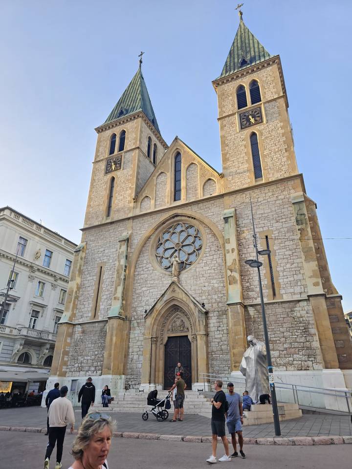 People gathered in front of a church with gothic architecture.