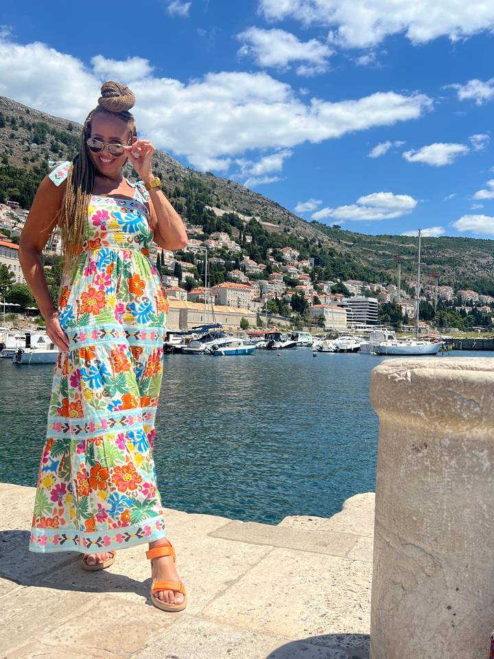 Female traveler posing by a seaside town.