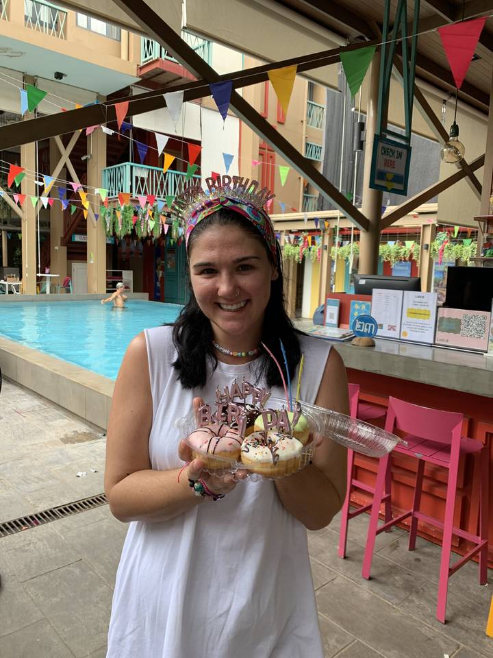 Woman holding a dessert in a festive setting.