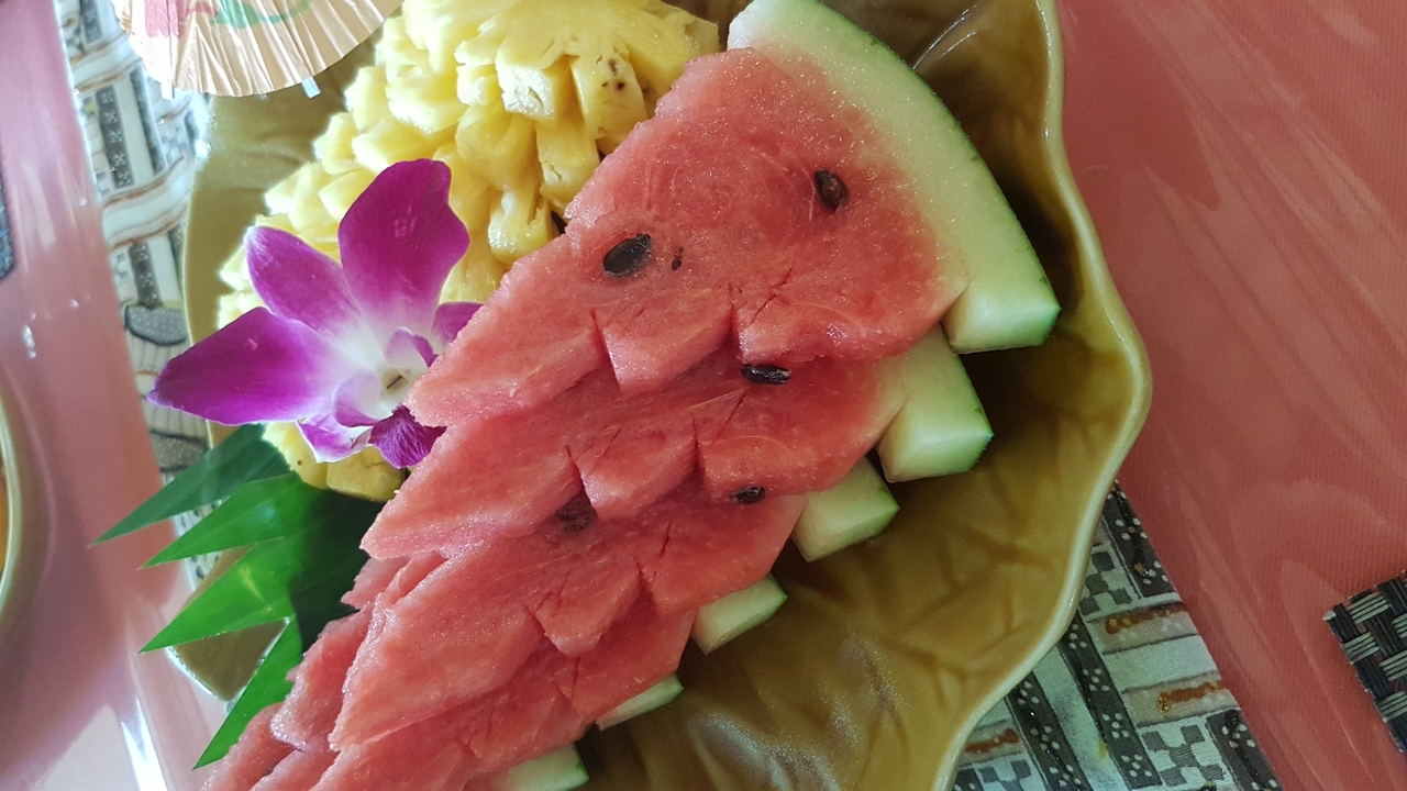 Assiette de fruits tropicaux décorée d'une fleur.