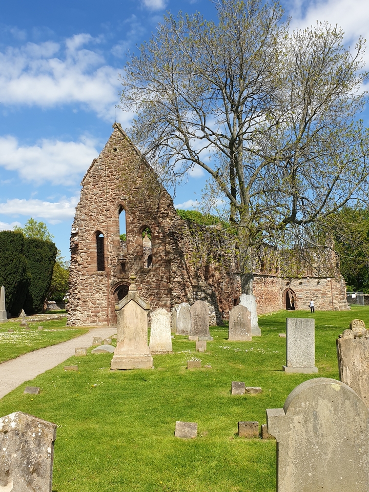 Ancient ruins with arched windows and gravestones.
