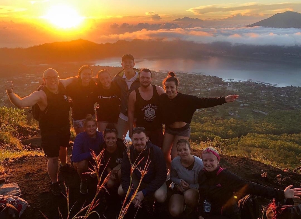Group of people posing with a stunning sunset view.