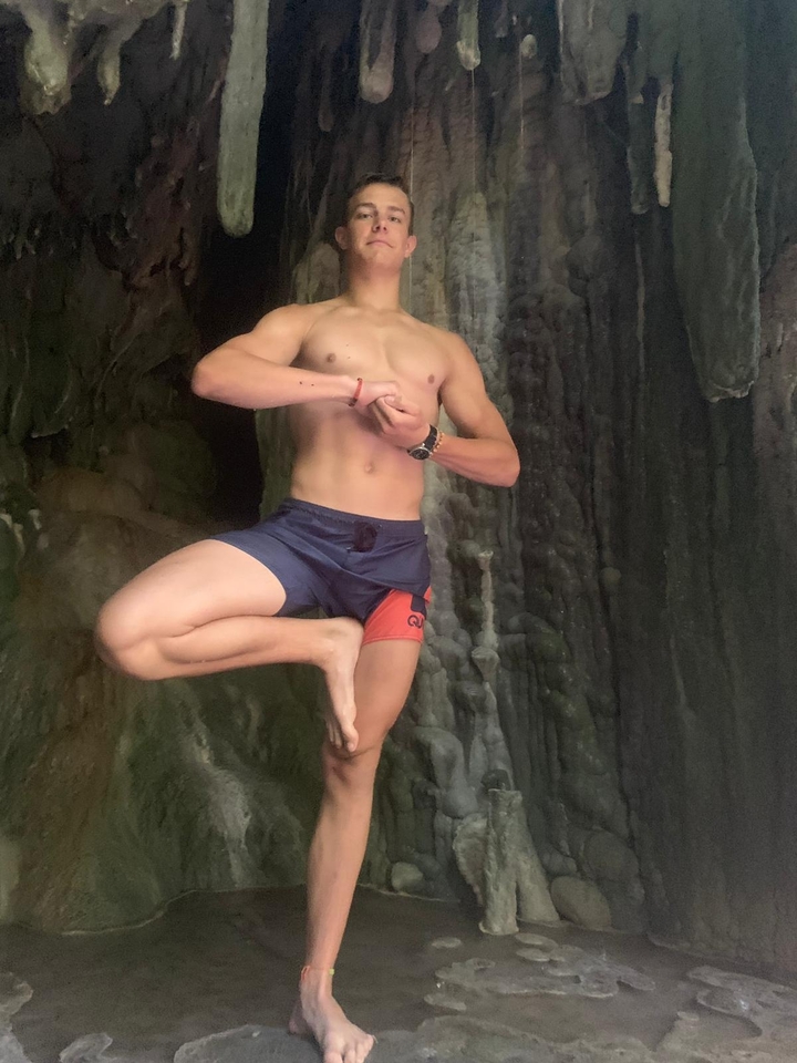 Personne qui pose dans une position de yoga dans une grotte.