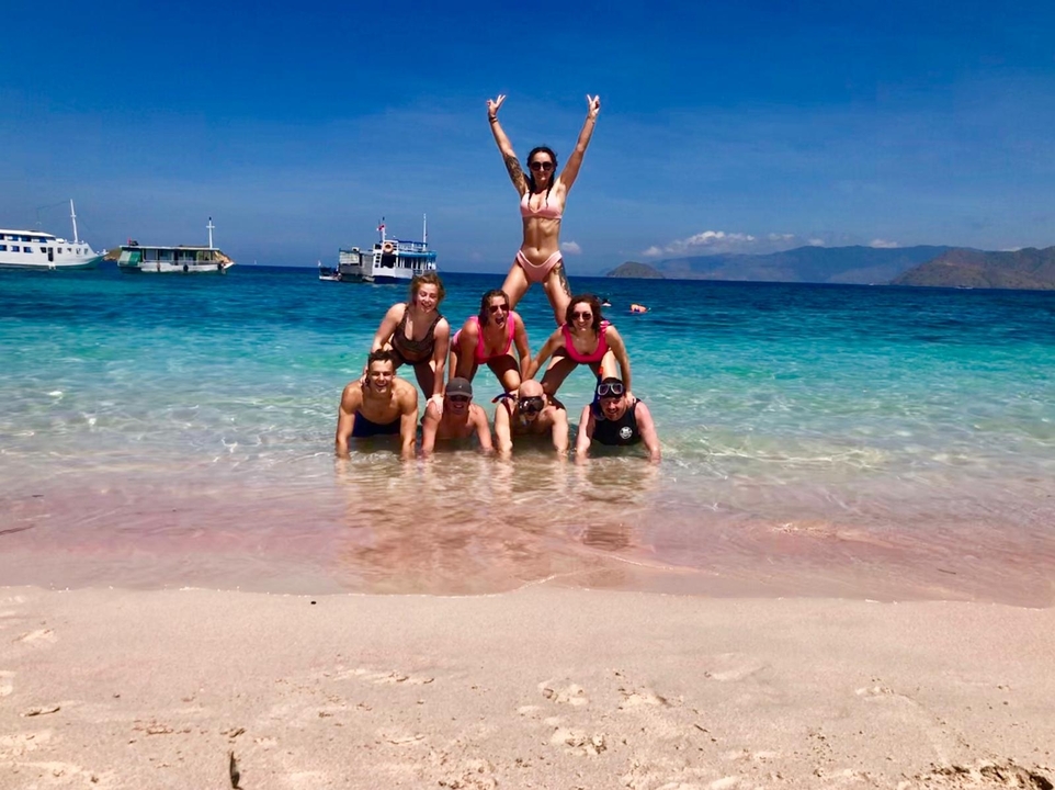 Groupe formant une pyramide humaine dans des eaux marines peu profondes.