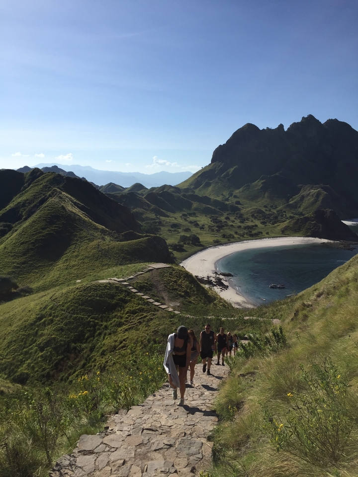 Vue panoramique d'une baie avec des collines et une plage.