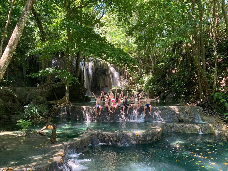 Groupe de personnes profitant d'une cascade dans une forêt.