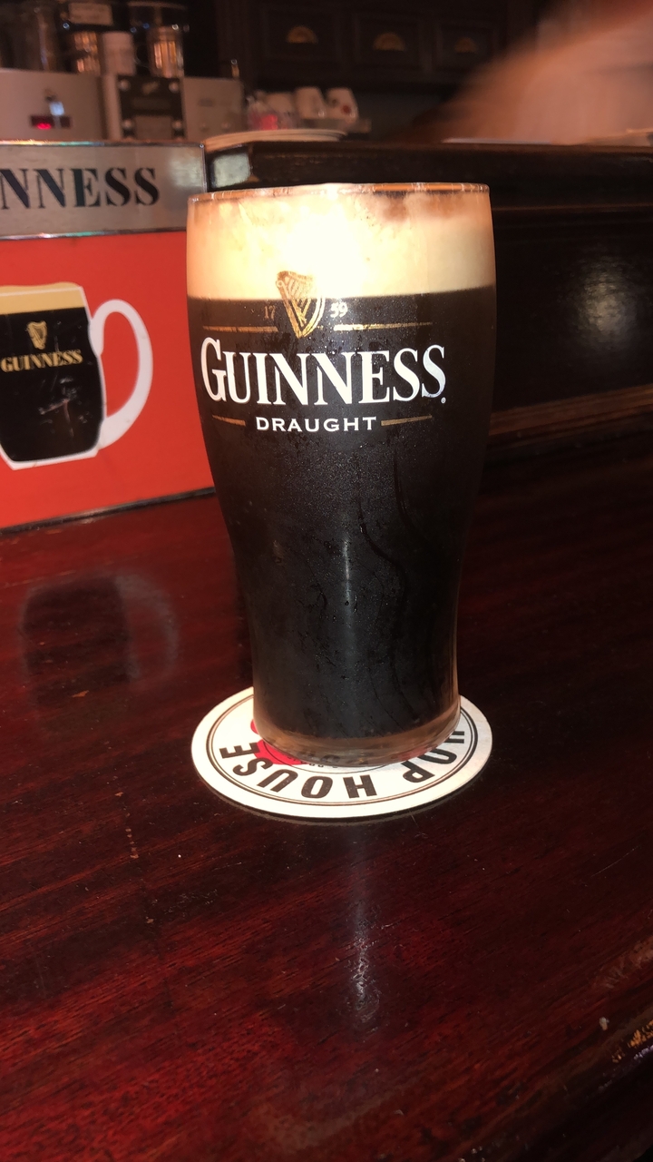 Bière stout brune dans un verre à pinte sur un sous-verre.