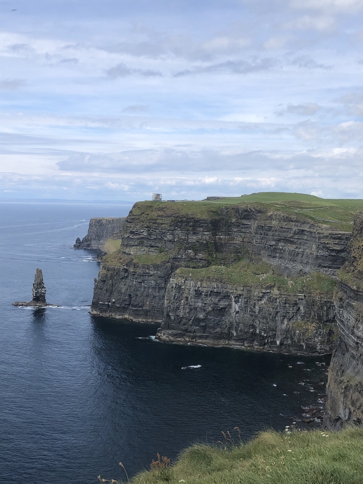 Cliffs with ocean below and a watchtower on top.