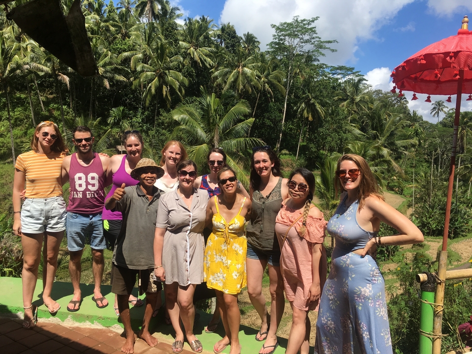 Group photo with a lush tropical backdrop.