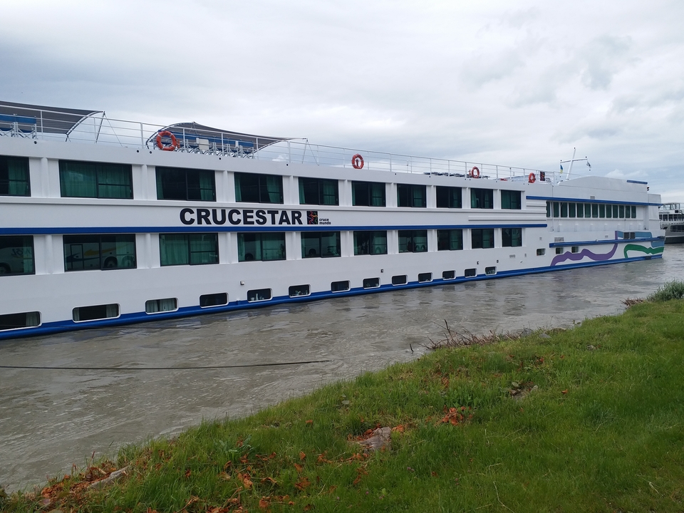 Un grand navire de croisière nommé Crucestar a accosté le long d'une rivière.