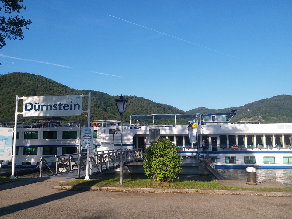 Un navire de croisière amarré à Dürnstein avec les collines environnantes.