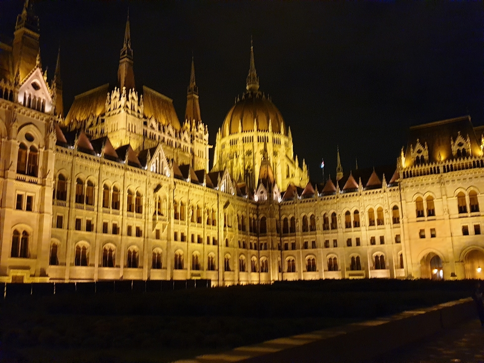 Un grand bâtiment illuminé avec une architecture complexe la nuit.