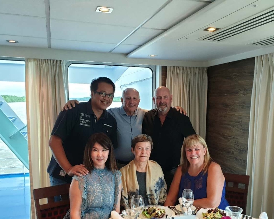 Un groupe de personnes posant dans une pièce avec une fenêtre en arrière-plan.