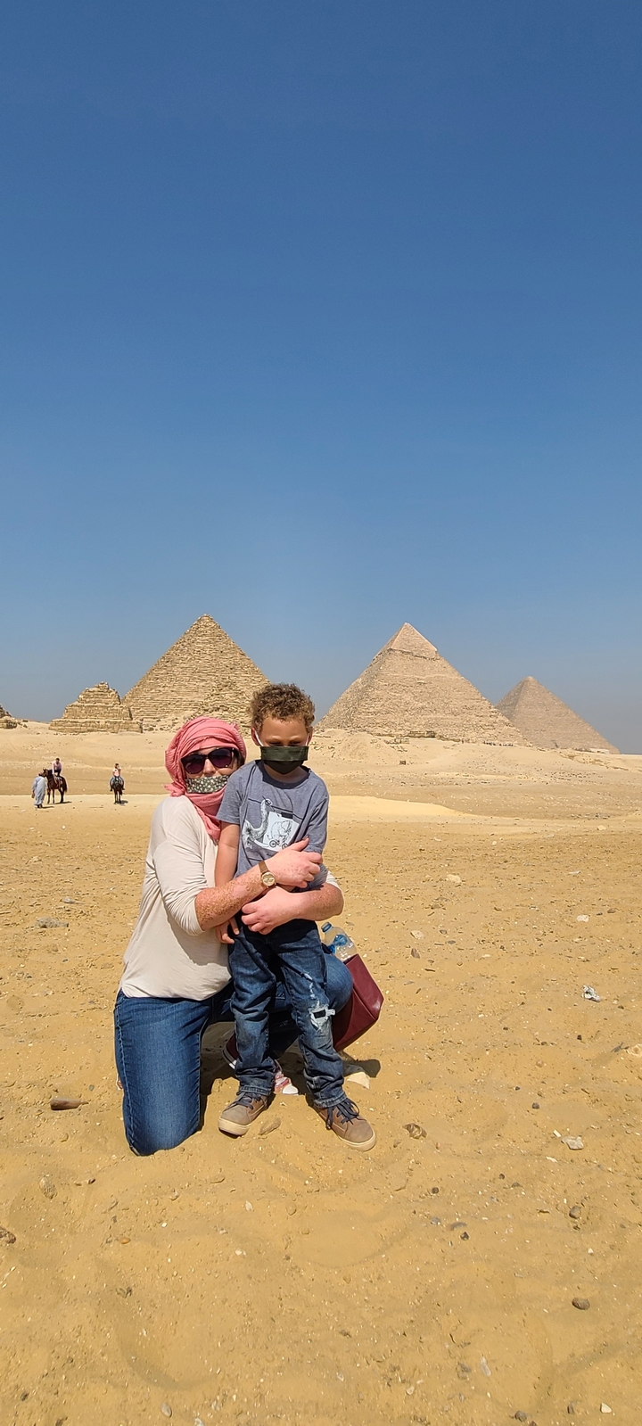 Visitors posing in front of pyramids in Egypt.
