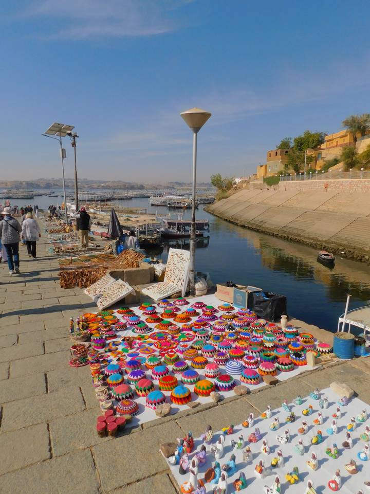 Market stall with colorful crafts by the riverbank.