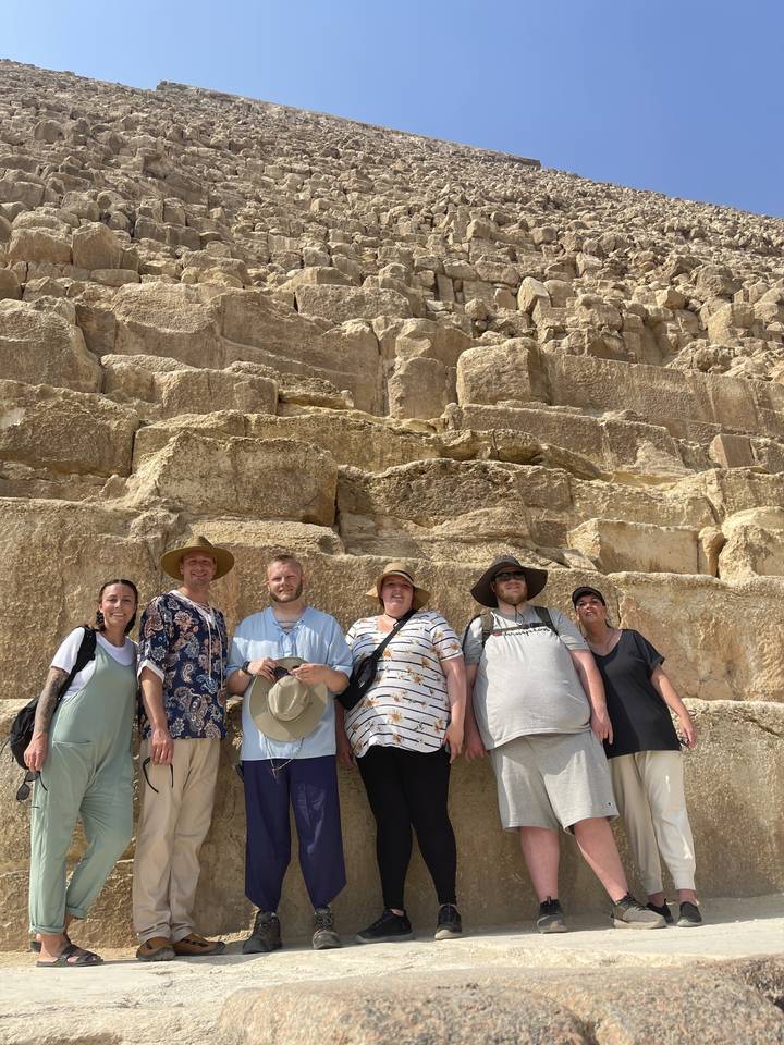 Group photo in front of a large stone structure.