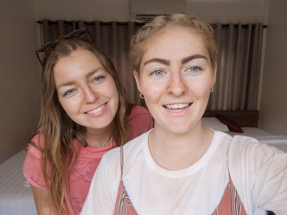 Two smiling women posing indoors.