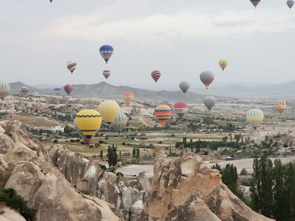 Hot air balloons floating over a rocky landscape.
