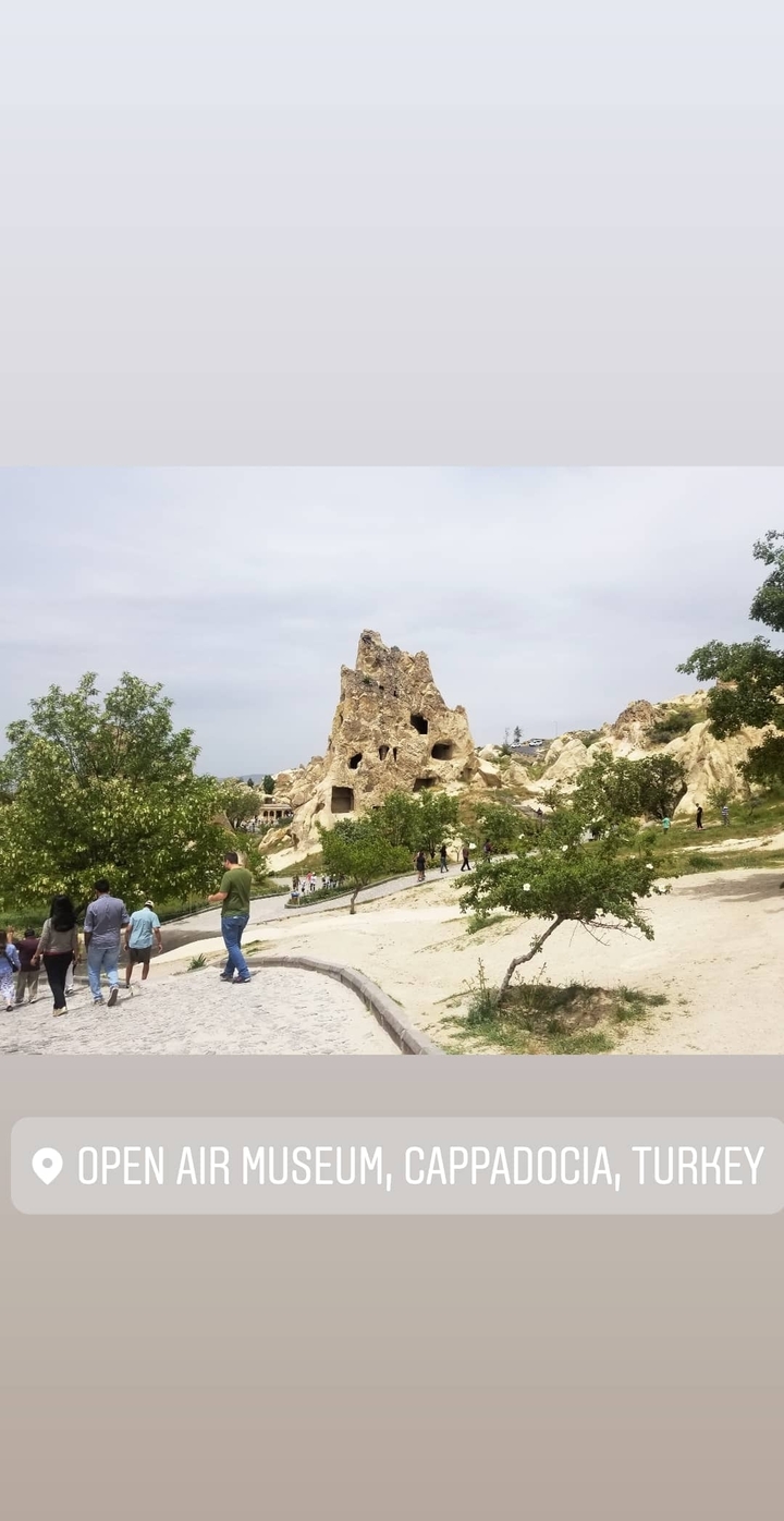 People visiting rock formations with cave dwellings.