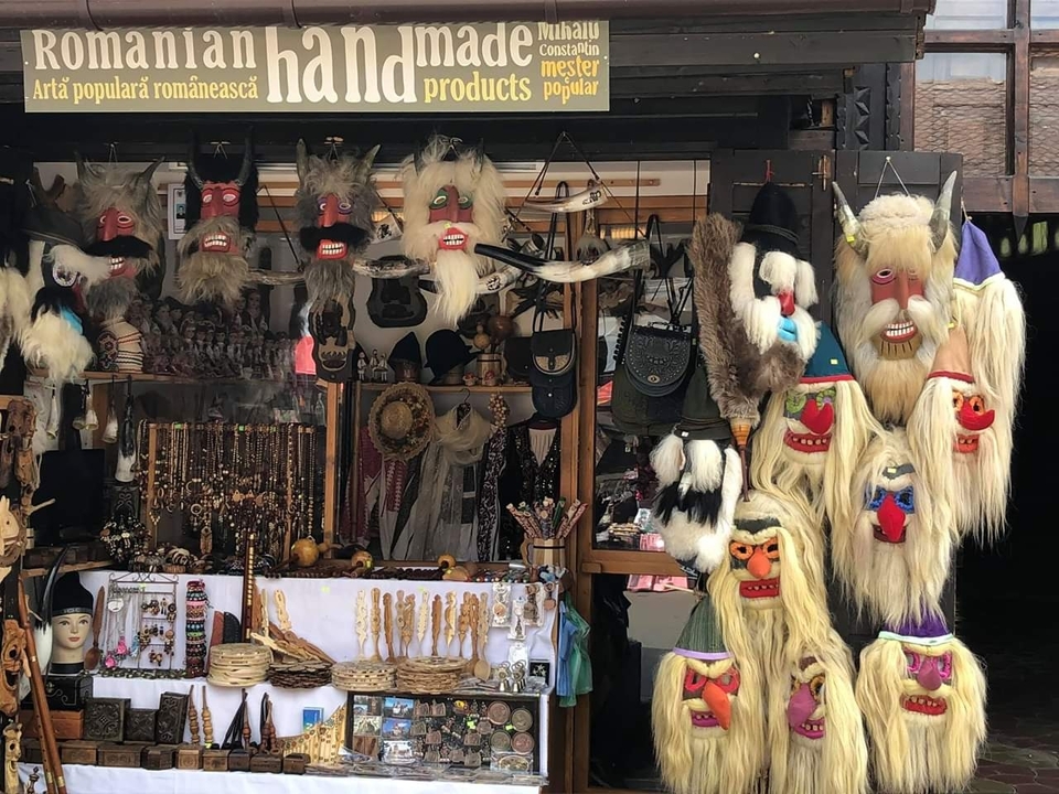 A display of traditional masks and crafts at a market stall.