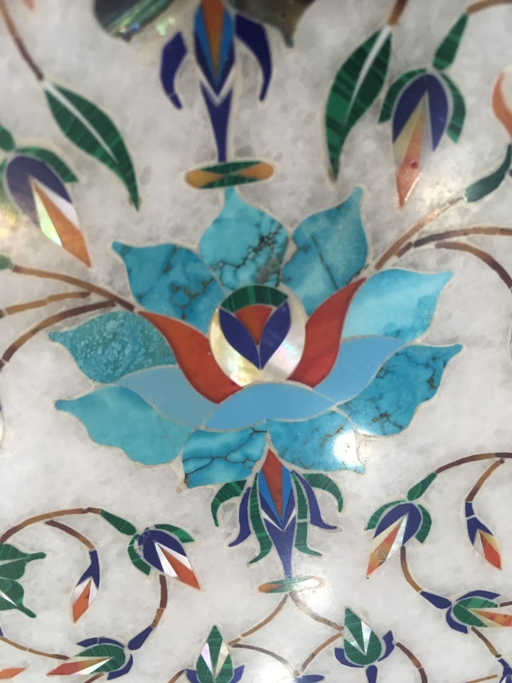 Detailed view of a stone inlay artwork with a blue flower design.