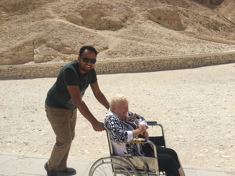 Person pushing another in a wheelchair.