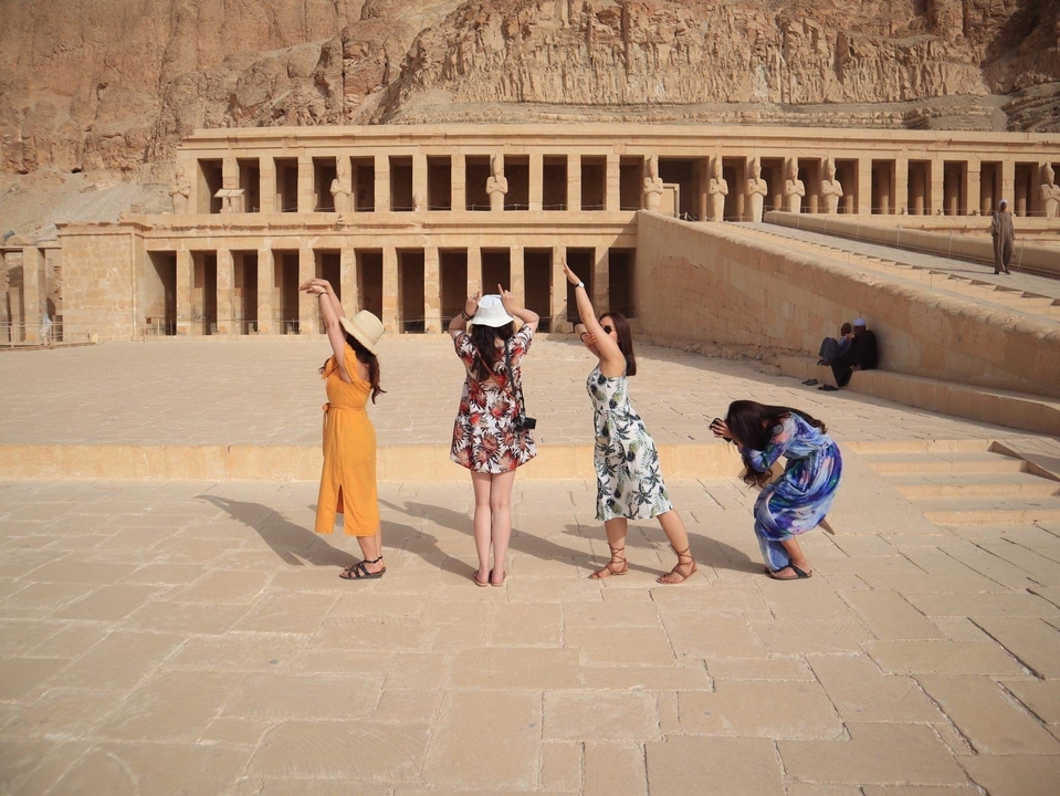Four people posing with historical architecture.
