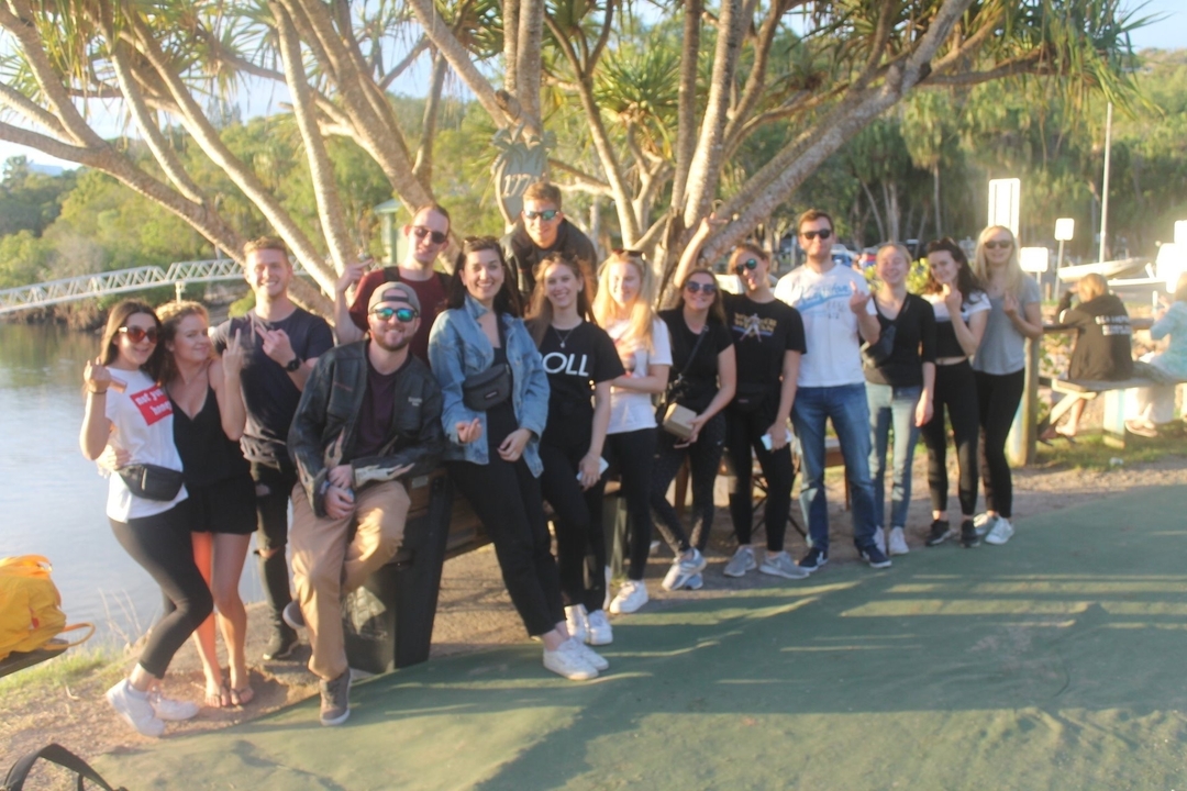 Group of people posing near a body of water.