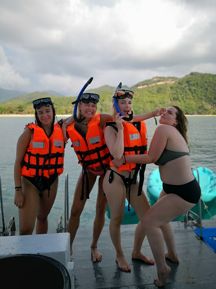 Group of people in life vests, preparing for a snorkeling activity.