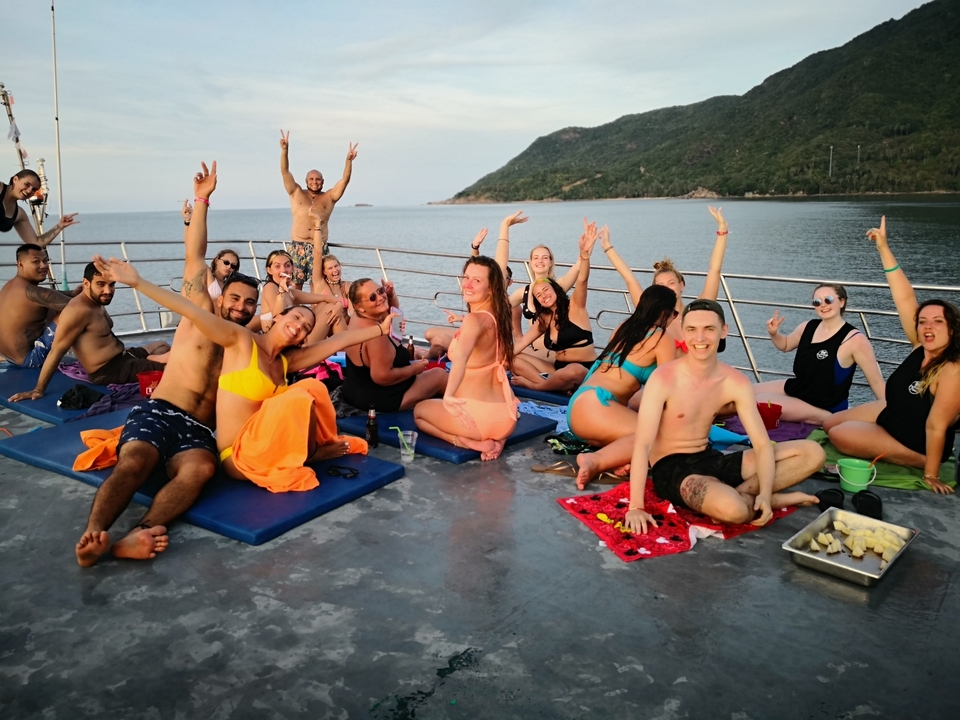 Group of people on a boat tour with a scenic backdrop.