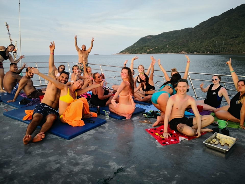 Group of people on a boat trip, smiling and posing.
