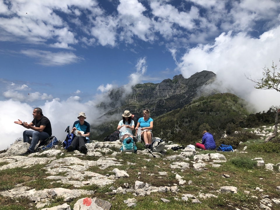 Un groupe de personnes se reposant sur des rochers avec vue sur la montagne.