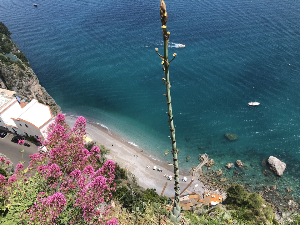 Vue aérienne d'une zone côtière et d'une plage avec des eaux bleues.